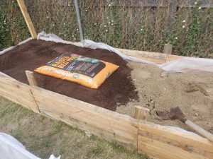 The finished garden bed made from recycled wood panels with Soil