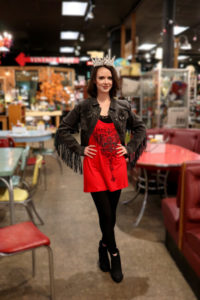 Girl with a crown inside a shop and a red dress for rodeo outfits